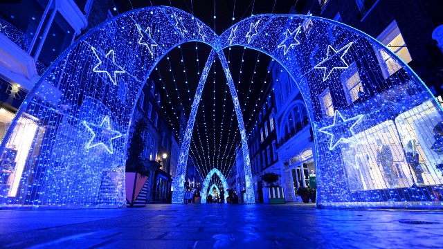 Riesige Bögen aus blauen LED-Weihnachtslichtern, die mit kleinen Lichtern und riesigen Sternen verziert sind. 