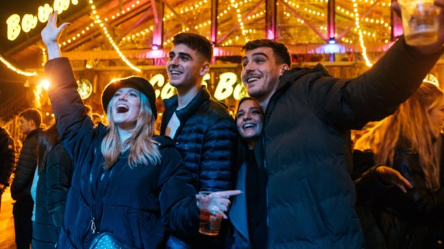A group of people sing along to live music in the Bavarian bar at Winter Wonderland in London.
