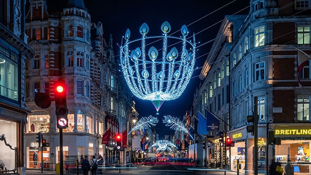 A blue-lit Christmas light installation hanging above Bond Street by night.