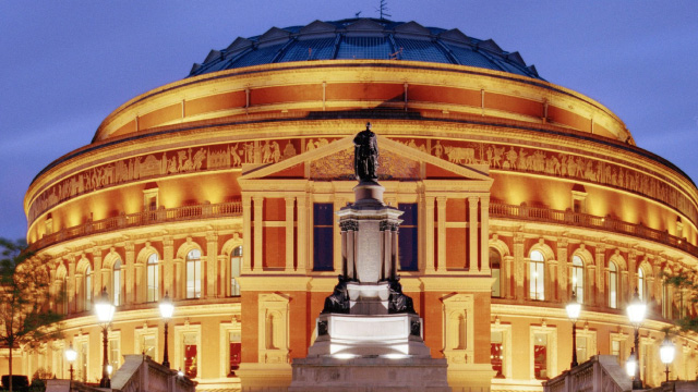Lit exterior of Royal Albert Hall at dusk in London