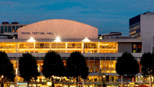 Lit exterior of Royal Festival Hall at dusk in London