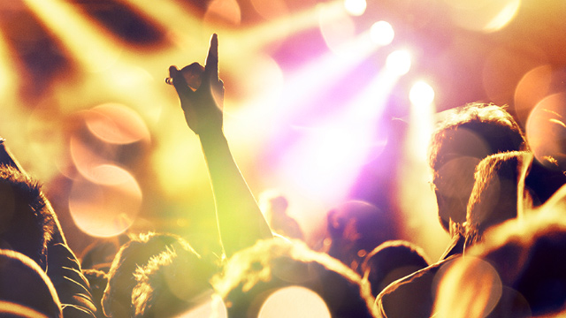 Crowds with their hands up in the air enjoying a live music concert in London.