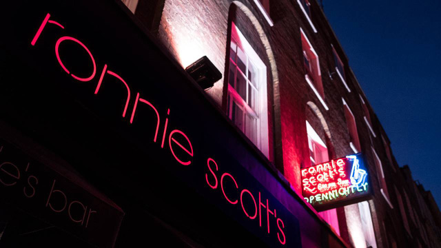 Lit sign above Ronnie Scott's jazz club at night in Soho, London