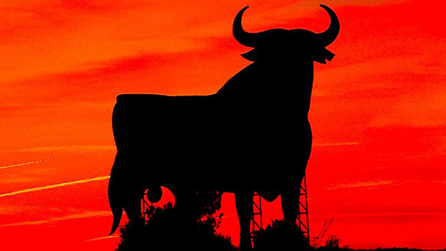 Eine schwarze Silhouette eines Stiers vor einem roten Hintergrund.