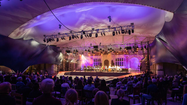 Lights illuminate the stage in front of a big audience at Opera Holland Park, London