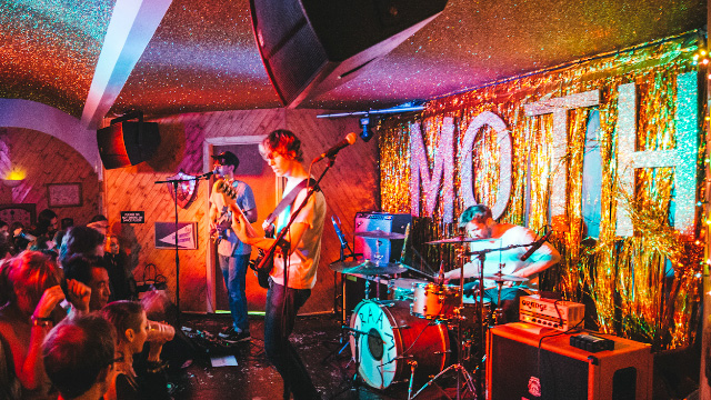 Crowd of people listening to musicians on stage at MOTH Club in East London