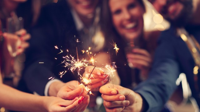 Un groupe d'amis rigolent et fêtent le Nouvel An avec des sparklers