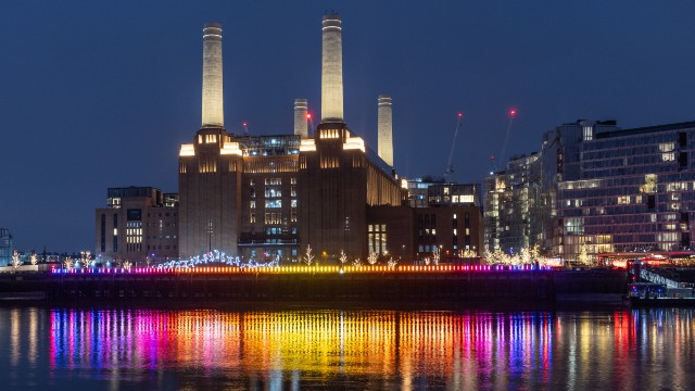 Colourful lights reflect on the river with Battersea Power Station in the backdrop