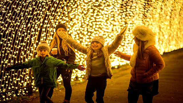 Children run through the cathedral of light tunnel at christmas at kew gardens in london. 