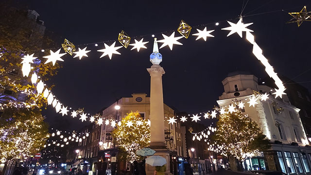 Glitzernde Weihnachtslichter umkreisen den berühmten Kreisverkehr in Seven Dials über den Menschenmassen