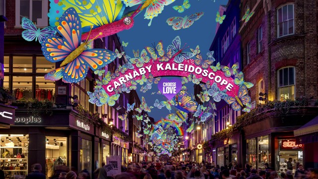 Butterfly light installations flutter above the streets of Carnaby as crowds look on at the display.