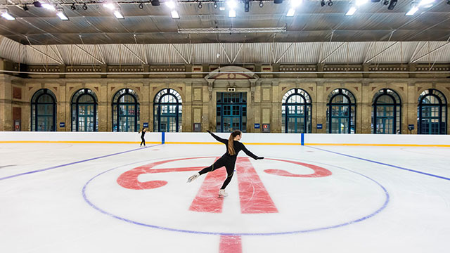 A girl ice skating on the ice rink at Alexandra Palace during the daytime