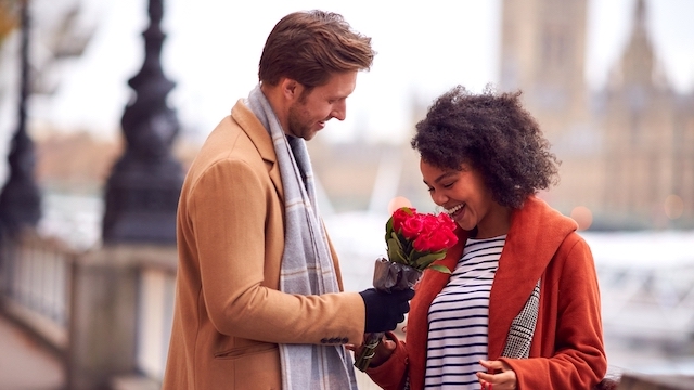 A man gives flowers to a woman outside of the Houses of Parliament in London on Valentine's Day.