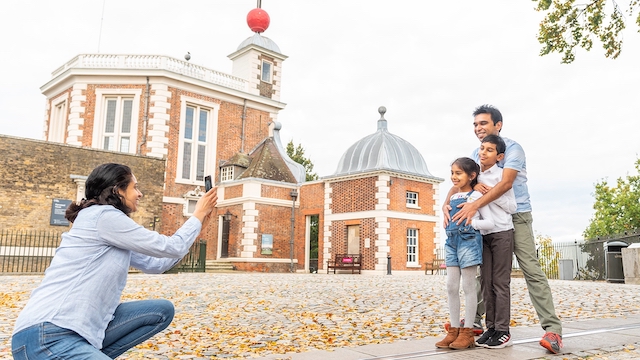 A mother takes a photo of her family at the Royal Observatory in Greenwich, London.