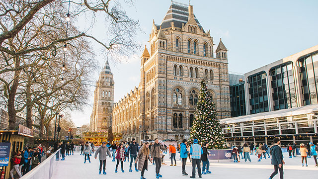 People skating at the Natural History Museum ice rink on a sunny winter's day