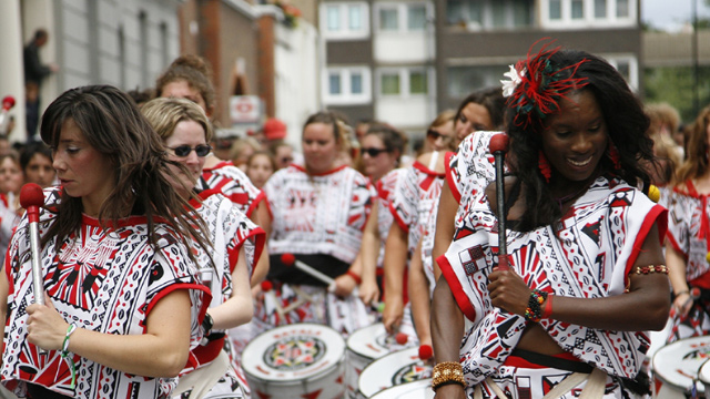Women play the drums in the streets of west London during Notting Hill Carnival.