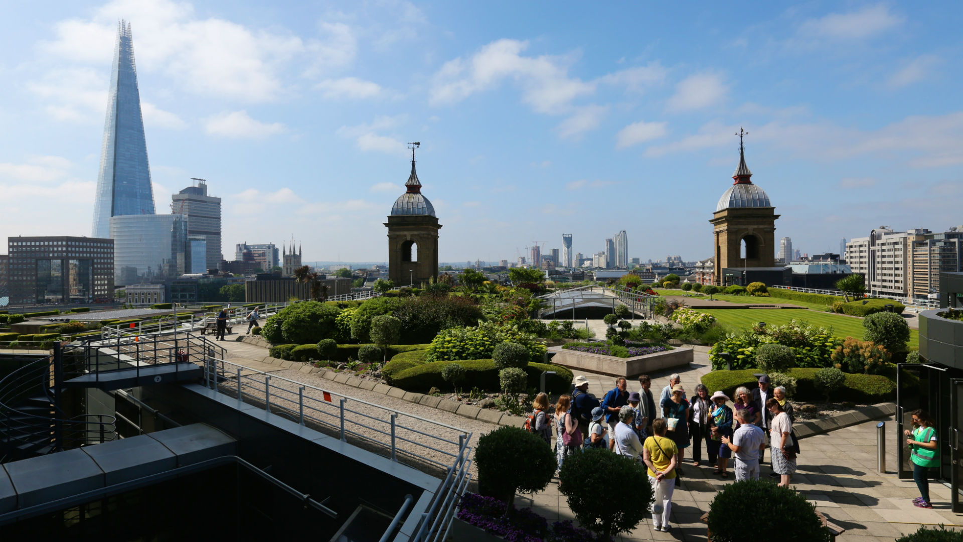 A roof garden on a sunny day with London's panorama, featuring The Shard, in the background. 