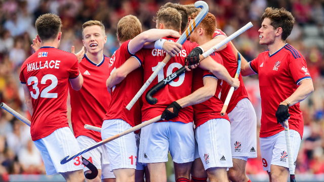 The men's hockey team huddle together in a group to celebrate a goal during the match
