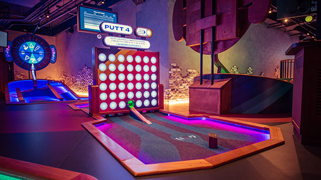 A brightly coloured neon golf obstacle at Puttshack