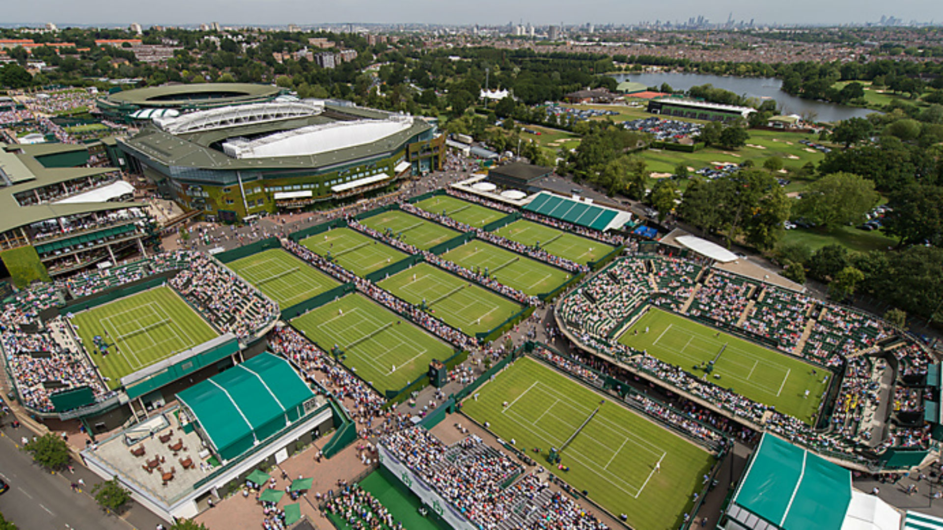 An aerial view of the tennis courts overlooking Wimbledon on day one of The Championships 2015 at The All England Lawn Tennis Club with London's panorama in the background