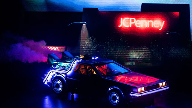Marty McFly conduit sa voiture dans le noir sous des lumières bleues et rouges.