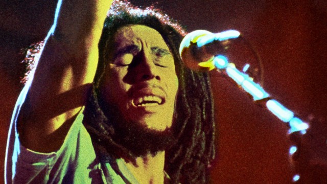 Gros plan du musicien Bob Marley se produisant sur scène.