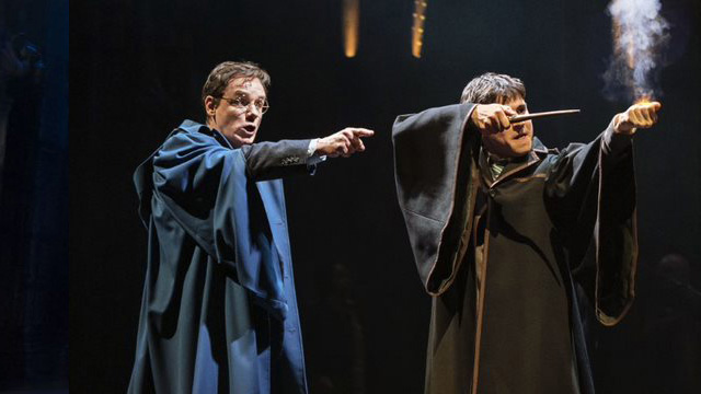 Two actors on stage performing magic at Harry Potter and the Cursed Child.