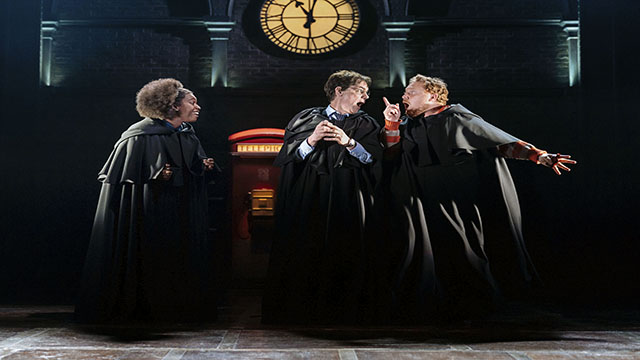 Harry Potter und seine beiden treuen Freunde, Hermine und Ron Weasley, stehen auf der Bühne und führen vor dem Zaubereiministerium ein sehr lebhaftes Gespräch.