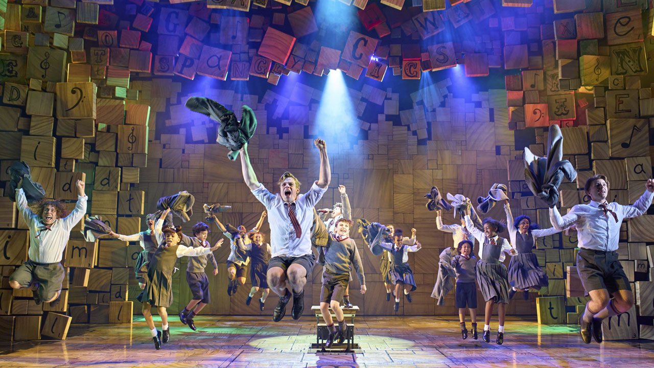 Children wearing school unifrms are jumping on stage during one of Matilda The Musical performances.