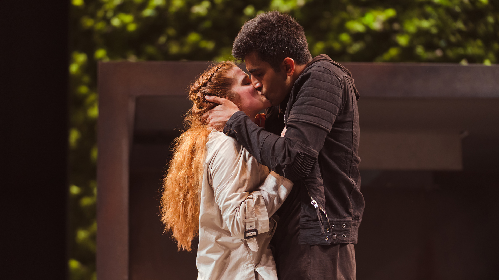 Romeo and Juliet embrace in front of a doorway.