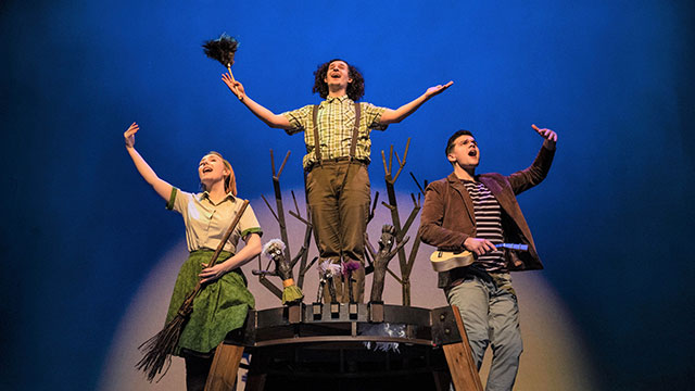 The cast and characters of Stick Man on stage under the spotlight