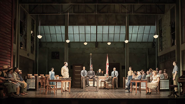 Scene of a courtroom where the lawyer faces the jury and defends his case in the play To Kill a Mockingbird in London.