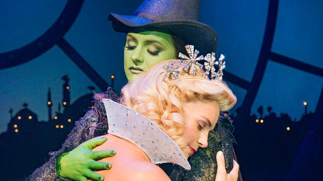 Helen Woolf (Glinda) and Nikki Bentley (Elphaba) embrace in award-winning london musical Wicked at Apollo Victoria Theatre. 