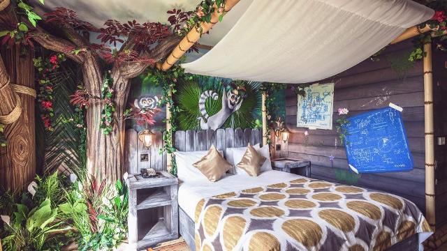 African-themed hotel room complete with colourful bed linens, plants and wooden features.