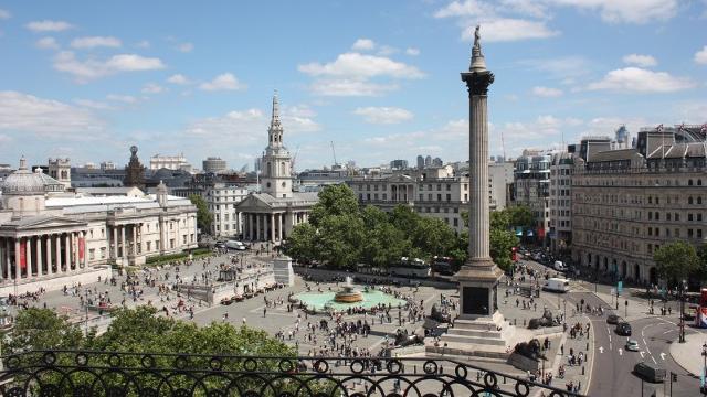 An aerial view of Trafalgar Square, taken from The Rooftop, including Nelson's column and the bronze lions, on a sunny day.