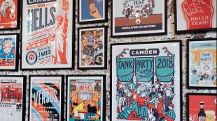A brightly coloured set of paintings and graphic art of Camden Town Brewery cover a wall.