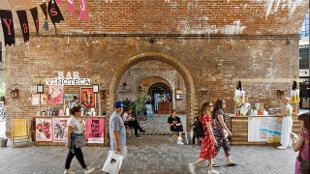 People walking through an arch at Borough Yards. Photo: Ed Reeve. Image courtesy of Monfort.