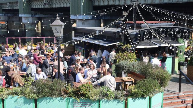 People sitting at tables in the outside space. Image courtesy of Greene King. People sitting at tables in the outside space. Image courtesy of Greene King.