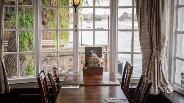 A table in the window with a view of the river. Image courtesy of Greene King. A table in the window with a view of the river. Image courtesy of Greene King.