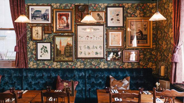 A wall full of pictures above tables and chairs. Image courtesy of Greene King. A wall full of pictures above tables and chairs. Image courtesy of Greene King.