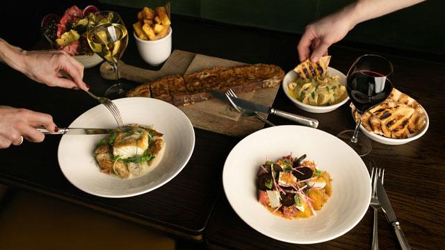 Main courses on a table. Credit: Raffaella Bichiri. Image courtesy of Langham Hotels.