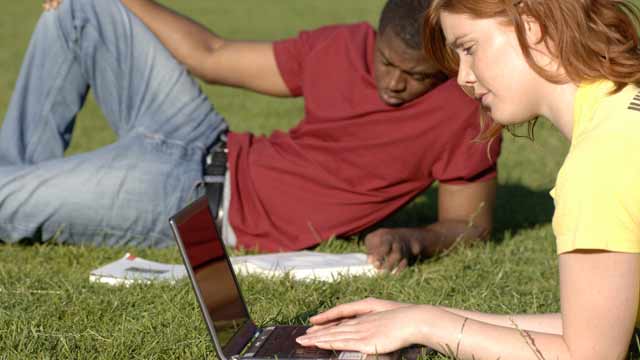 Two students on the grass studying ©VisitBritain/ Eric Nathan