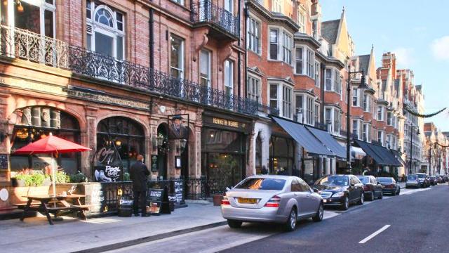 Shoppers pass high end shops on London's Bond Street. Known for